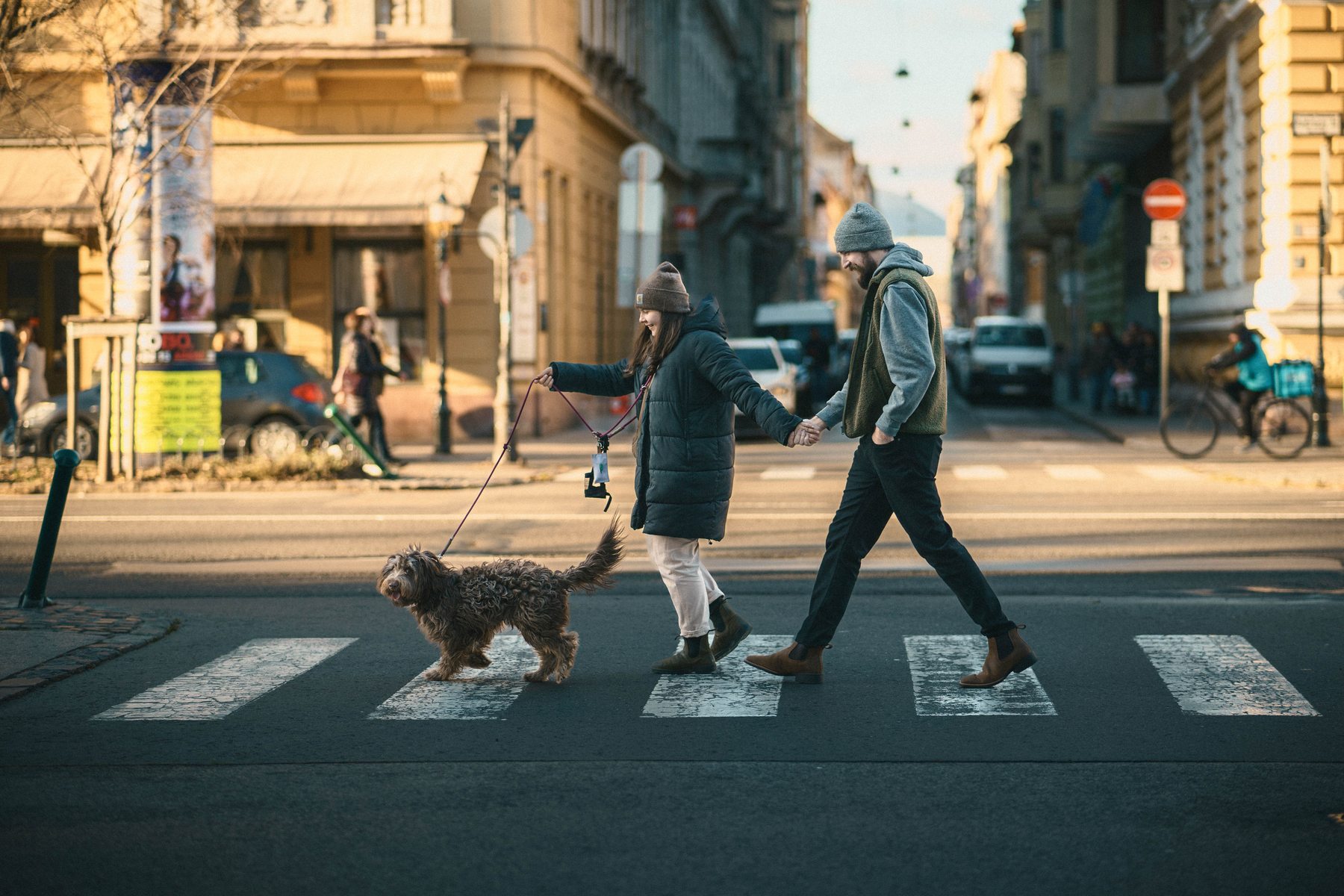 Pár a kutyájukkal sétál a városban